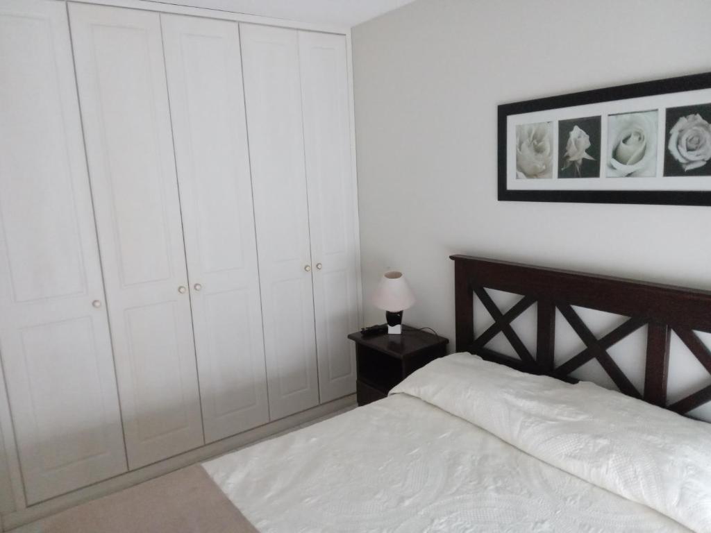 1 dormitorio con armarios blancos y 1 cama en Aptos en 12 Lunas, en Punta del Este