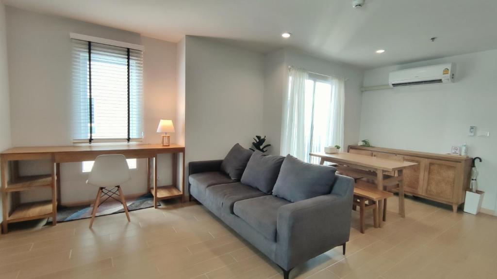 sala de estar con sofá y piano en Cozy 1-bedroom condo close to MRT near JJ market en Bang Su