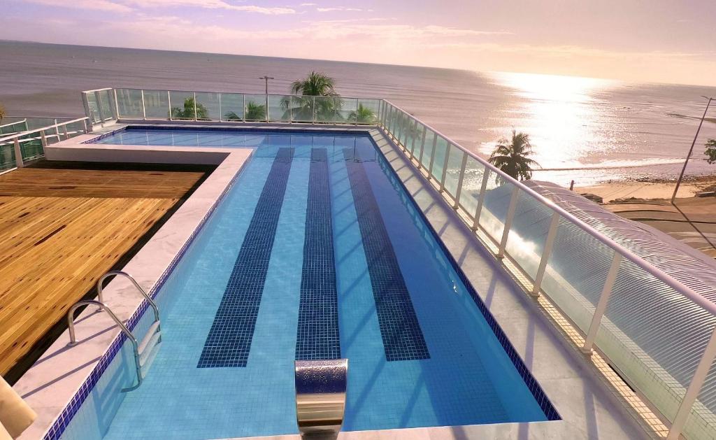 a swimming pool on top of a building next to the ocean at FHF Blue Suites in João Pessoa