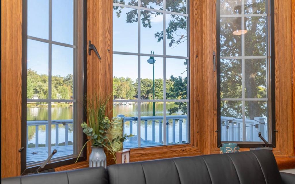 salon z dużymi oknami wychodzącymi na jezioro w obiekcie Hansen Bay Hideaway w mieście Rice Lake
