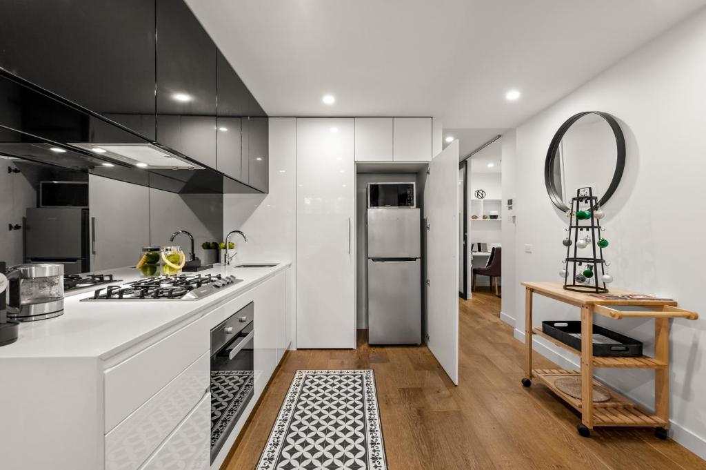 cocina con encimeras blancas y fogones en StayCentral - Hawthorn East - Study, 2 Car spaces en Melbourne