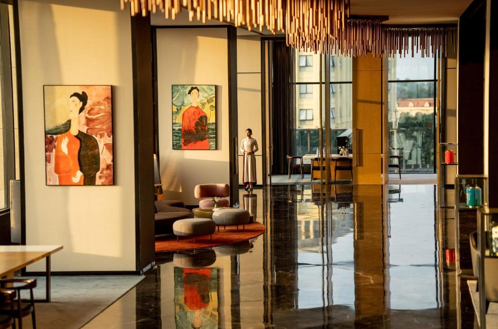 a living room with a lobby with paintings on the walls at Crowne Plaza Vinh Yen City Centre, an IHG Hotel in Yen