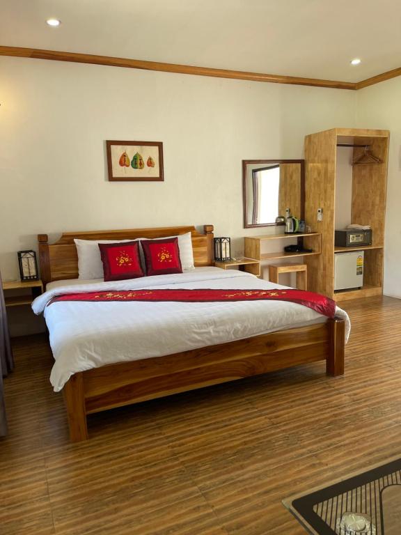 1 dormitorio con 1 cama grande con almohadas rojas en Liberty Place en Luang Prabang