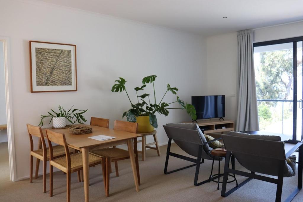 a living room with a dining room table and chairs at Lorne Surf Apartments in Lorne