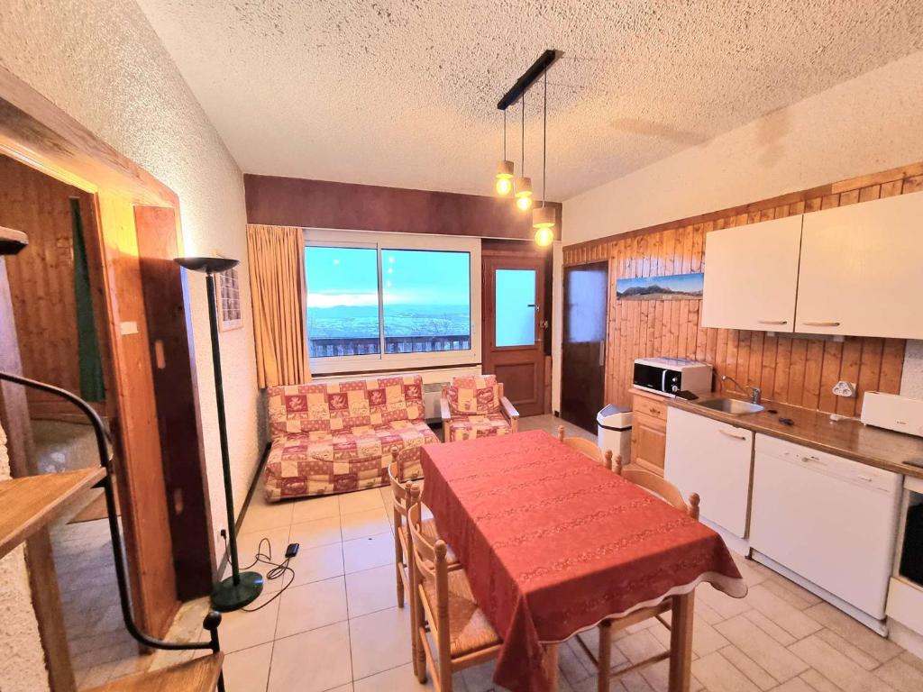 une cuisine et un salon avec une table et un canapé dans l'établissement Appartement cosy à Chaillol 1600, 6-8 pers, terrasse sud, WiFi, parking proche - FR-1-393-31, à Saint-Michel-de-Chaillol
