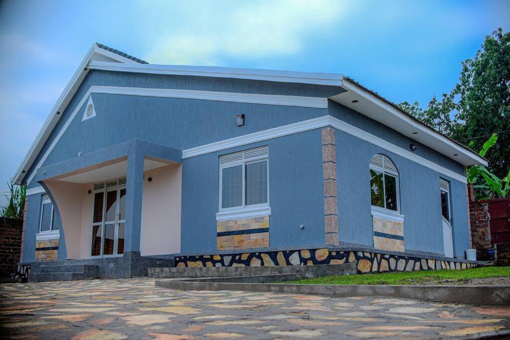 a blue house with a driveway in front of it at Home in Namugongo in Kampala