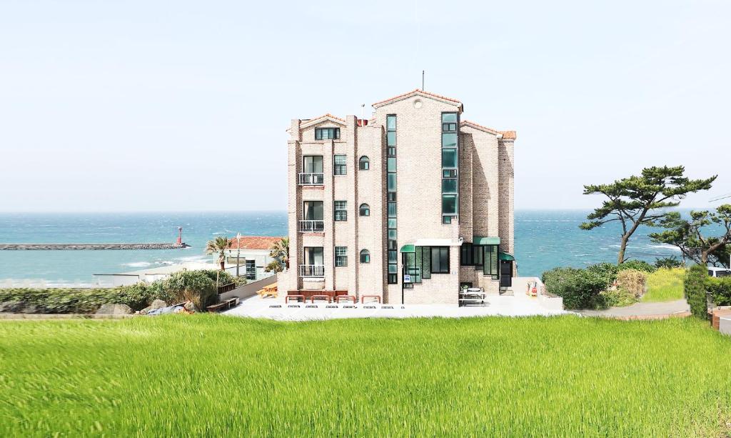 een groot gebouw met de oceaan op de achtergrond bij Sea View in Jeju-stad