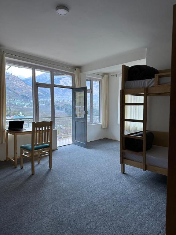 a bedroom with a bunk bed and a desk at La Heim Hostels in Manāli