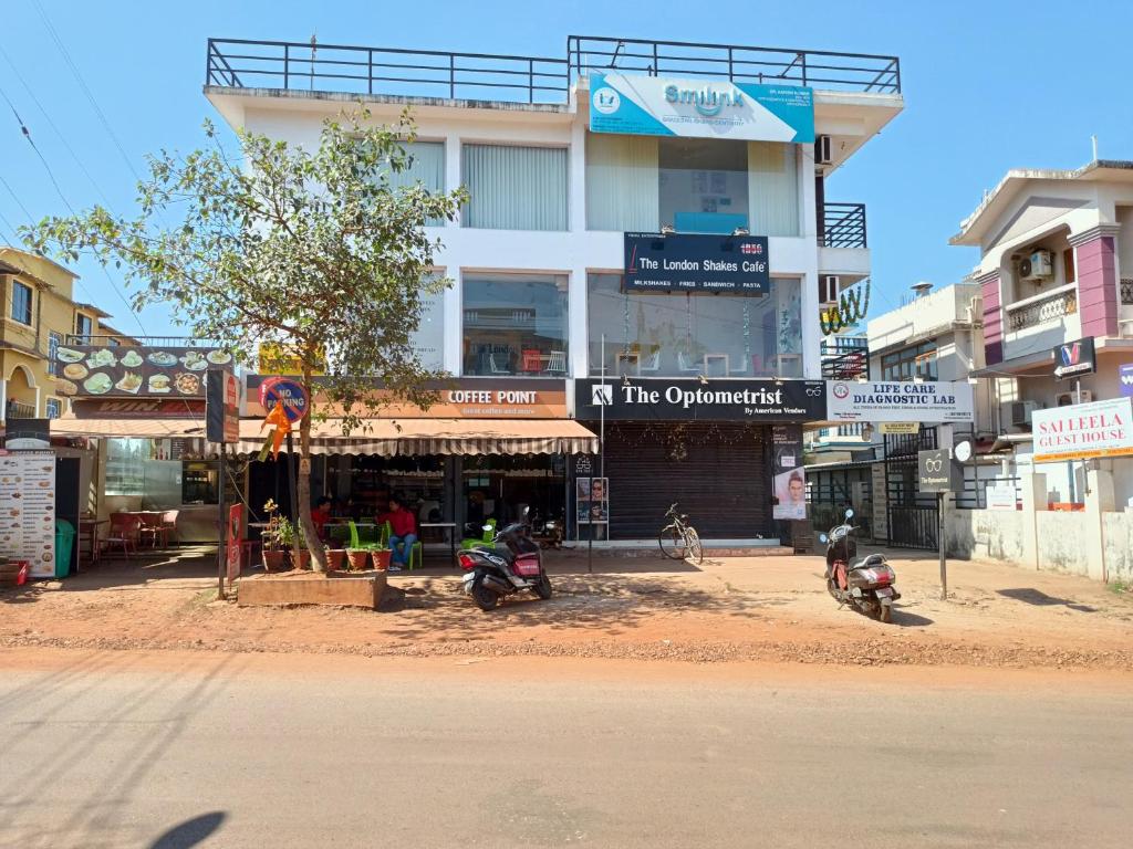 due moto sono parcheggiate di fronte a un edificio di Sai Leela Guest House a Dabolim