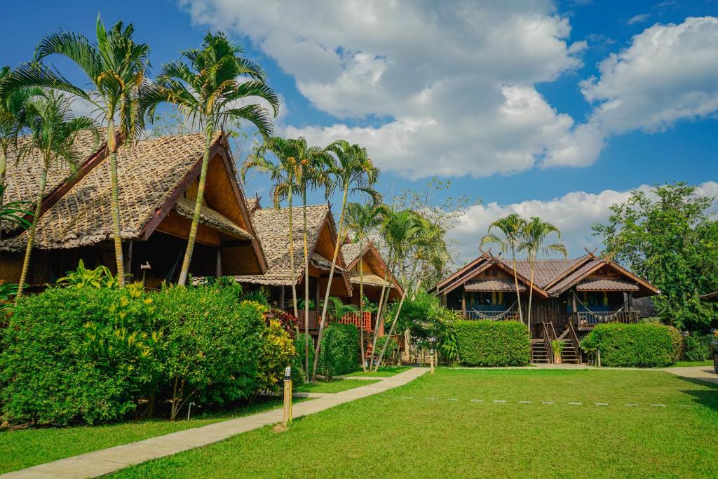 a resort with palm trees and a lawn at Pai Homey in Pai