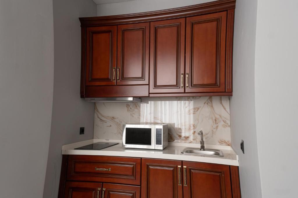a kitchen with a microwave and a sink at Mir Luxe Plaza in Tashkent