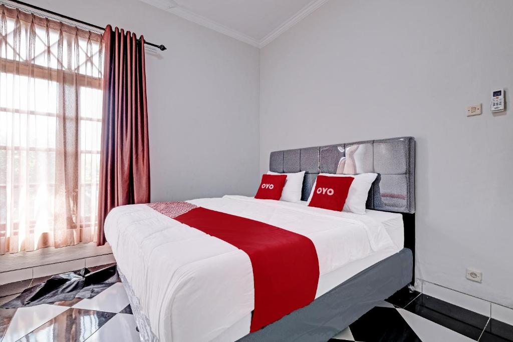 ein Schlafzimmer mit einem großen Bett mit roten Kissen in der Unterkunft OYO 92067 Sekar Gadung Homestay Syariah in Yogyakarta