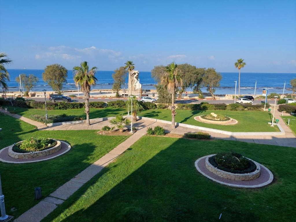 una vista aerea su un parco con palme e sull'oceano di First Sea Line Apartment, Acre - amazing coastal view in heart of Akko a ‘Akko