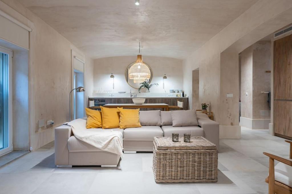 salon z białą kanapą i żółtymi poduszkami w obiekcie Sofisticado apartamento en frente a la playa w Maladze
