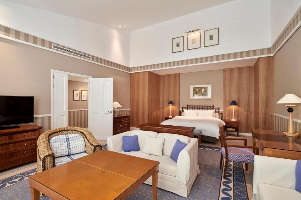 a hotel room with a bed and a living room at The Shilla Jeju in Seogwipo