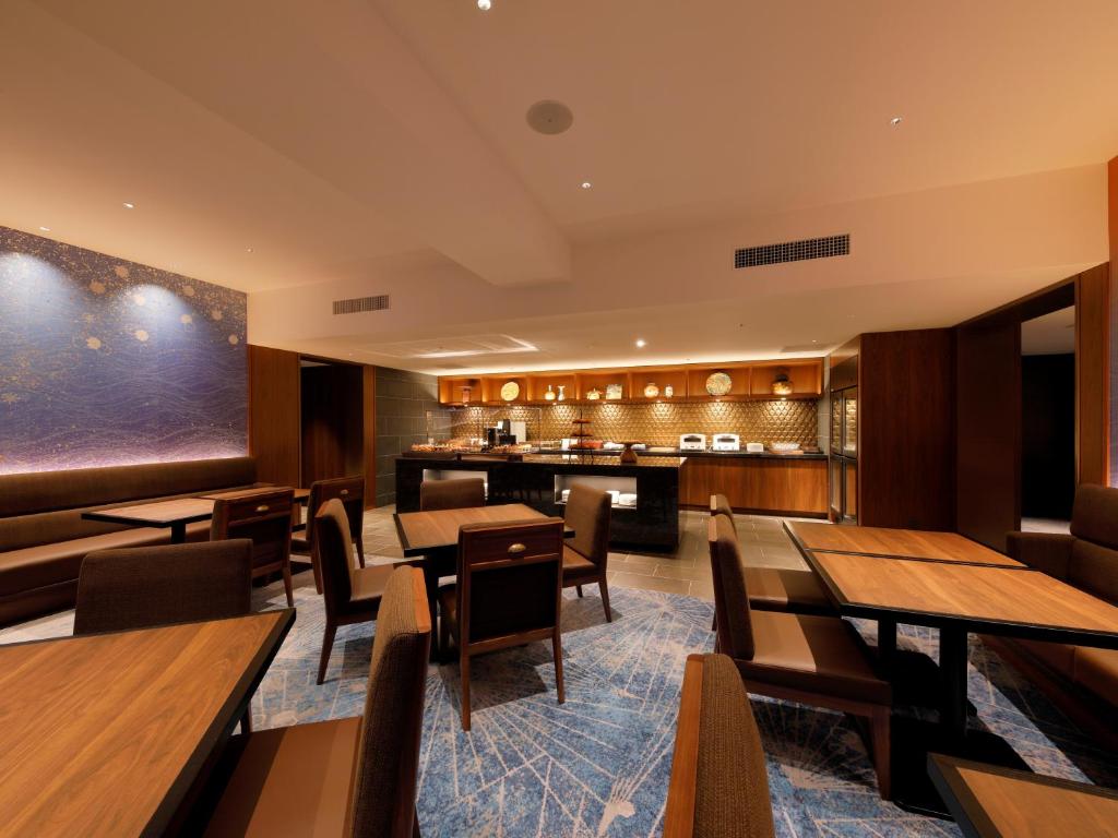 a restaurant with wooden tables and chairs at THE HOTEL SANRAKU KANAZAWA 21th December 2022 OPEN in Kanazawa