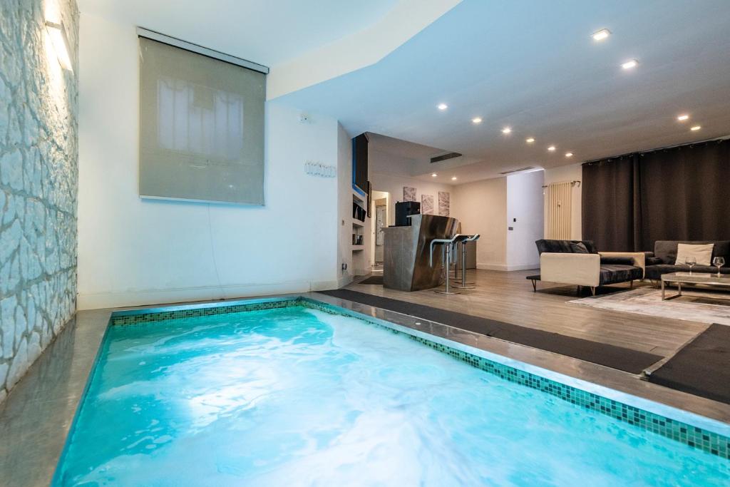 a large swimming pool in a living room with a tv at Design Apartment with private pool exclusive use - Stelvio 21 in Milan