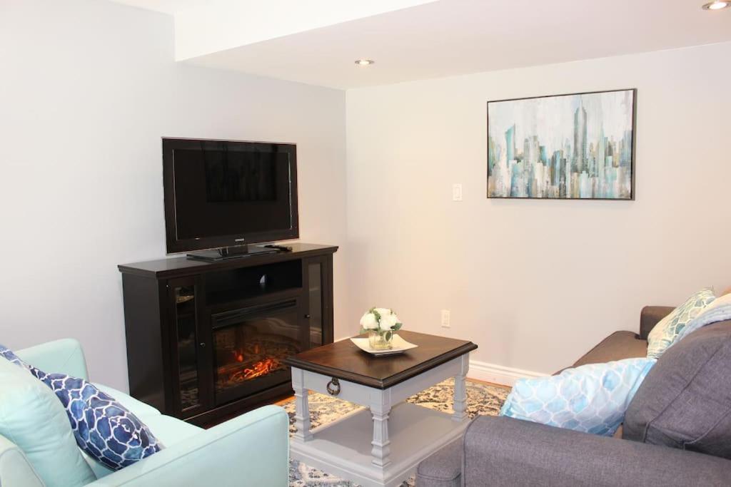 uma sala de estar com televisão e lareira em 2-Bedroom basement suite with a separate entrance. em Abbotsford