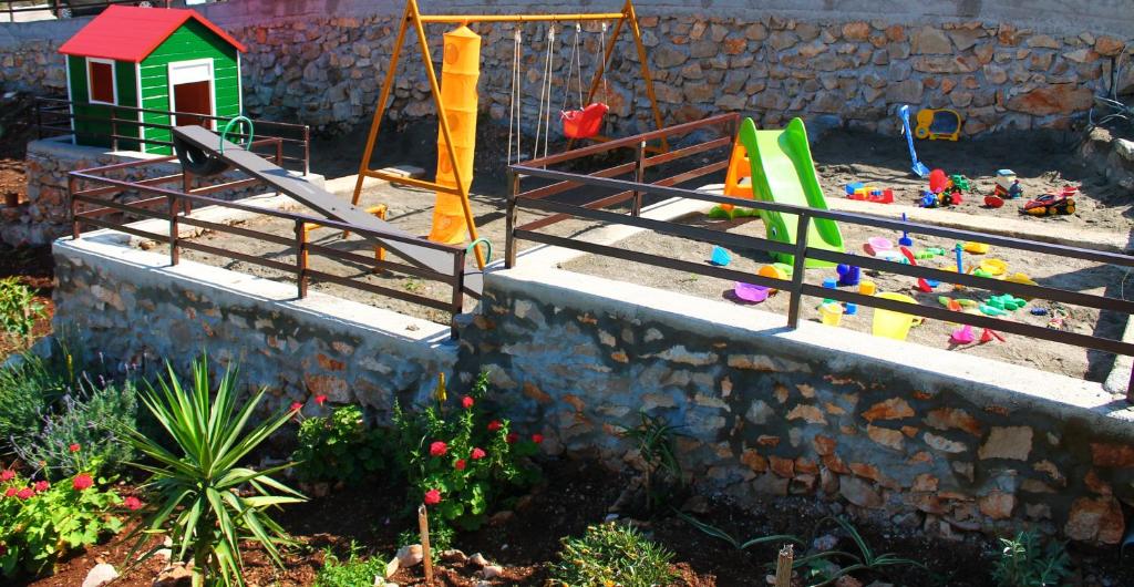 a childrens playground with a swing set and toys at Apartments Villa Milna 1 in Budva