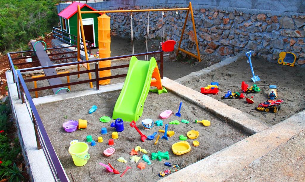 a childs play area with toys in a sandbox at Apartments Villa Milna 1 in Budva