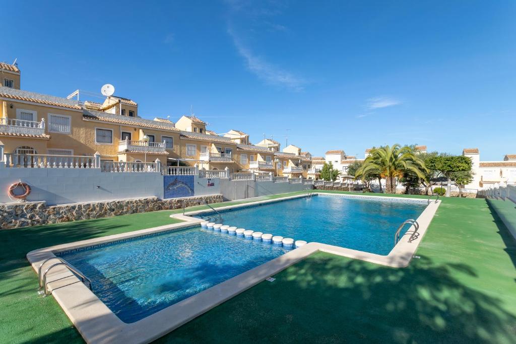 una piscina con una silla frente a un edificio en 3 Bedroom Holiday Villa Benani en Puerto Marino