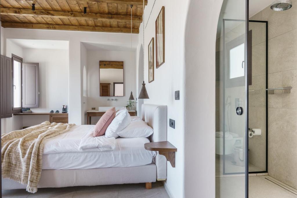 a bedroom with a bed and a glass shower at Pelican Bay Hotel in Platis Gialos