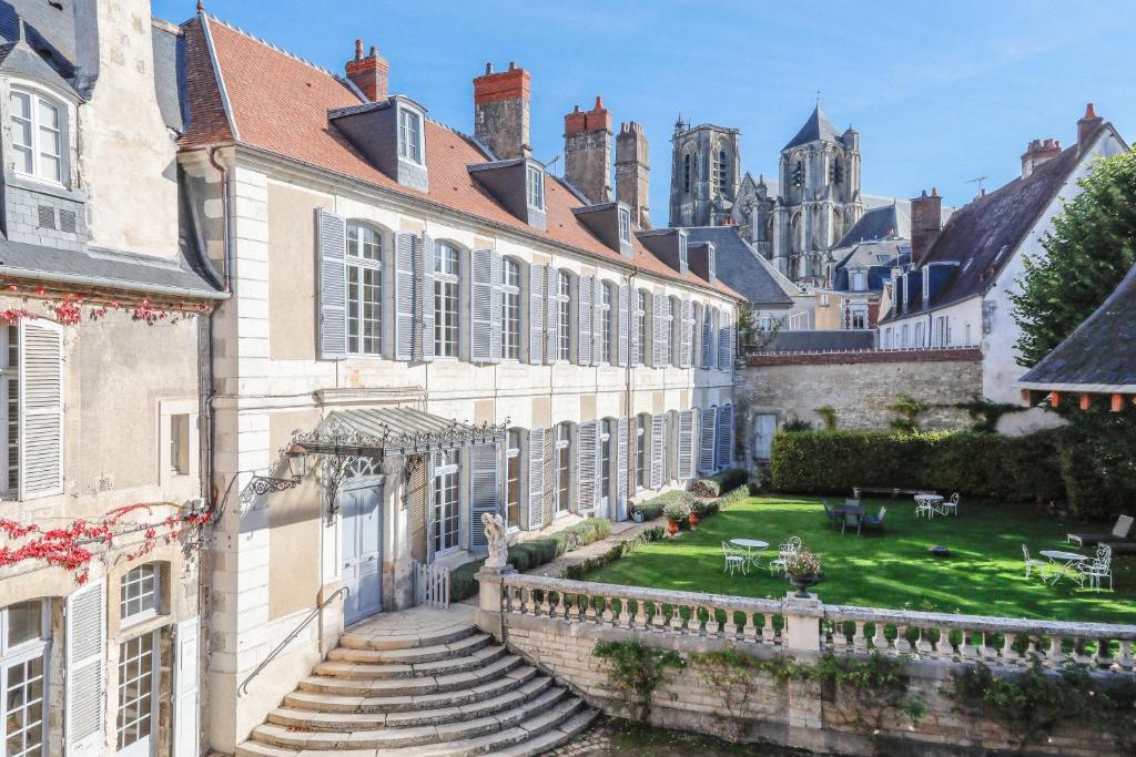 une cour d'un immeuble avec des escaliers et une cour dans l'établissement L'Hotel de Panette, Un exceptionnel château en ville, à Bourges