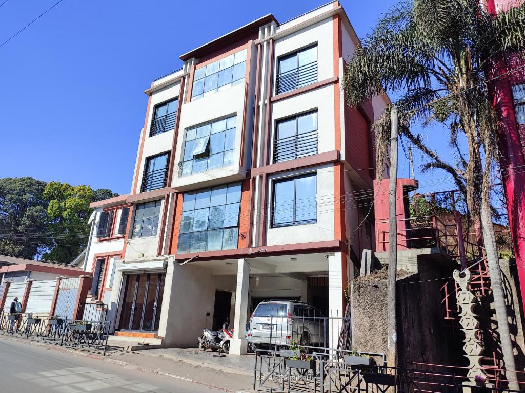 a building with a car parked in front of it at Valiha Serviced Apartments Antananarivo in Antananarivo