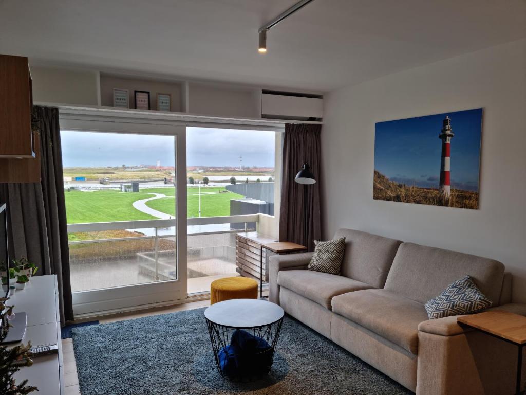 a living room with a couch and a lighthouse at Appartement 't Pand in Nieuwpoort
