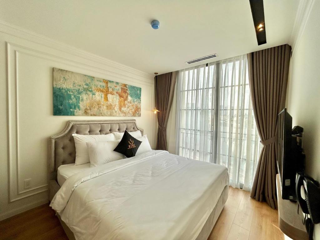 ein Schlafzimmer mit einem weißen Bett und einem großen Fenster in der Unterkunft Cityhouse S Home in Ho-Chi-Minh-Stadt