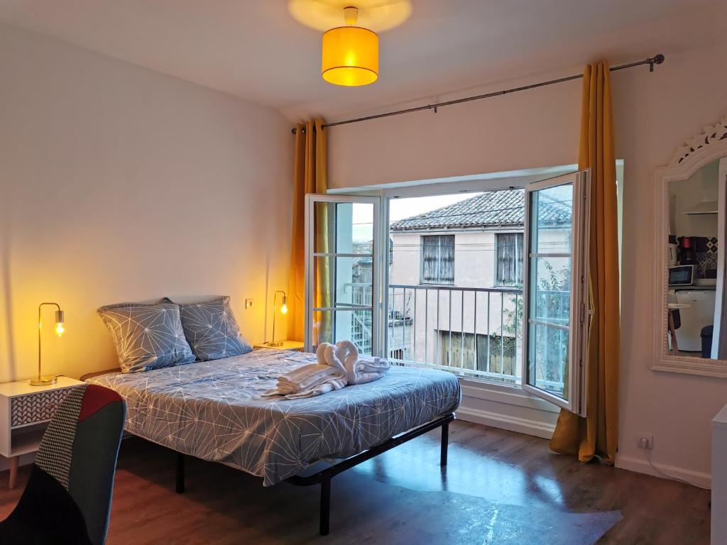 ein Schlafzimmer mit einem Bett und einem großen Fenster in der Unterkunft Studio ruffec 10 in Ruffec