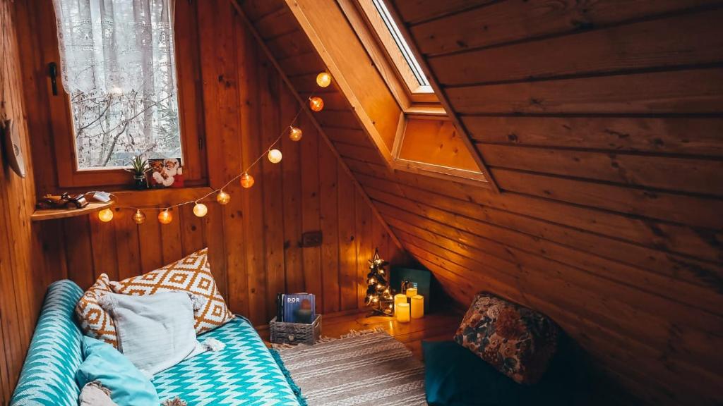 a room with a bed in a wooden wall at Tiny Wooden Cottage -Covasna in Reci