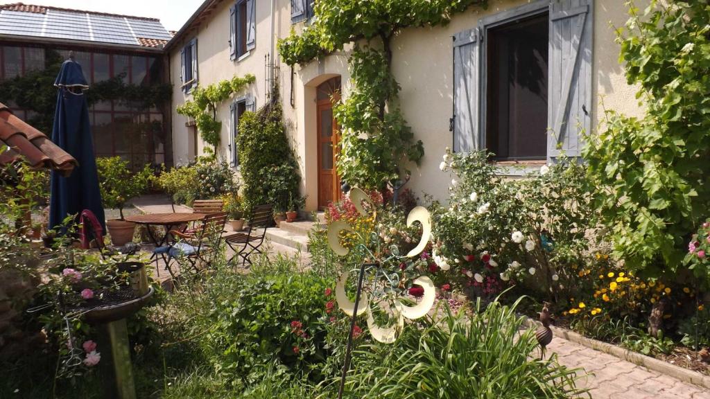 a garden in front of a house with flowers at Gîte Périssée1 in Libaros
