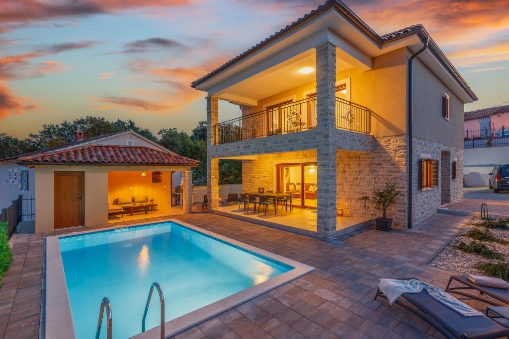 eine Villa mit einem Pool vor einem Haus in der Unterkunft Villa MONICA with private pool in Risika