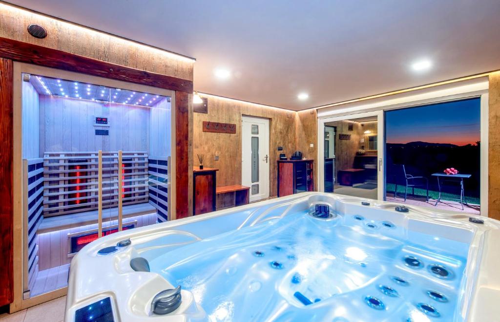 uma banheira de hidromassagem num quarto com vista em Bregec Tiny House and Wellness em Varaždinske Toplice