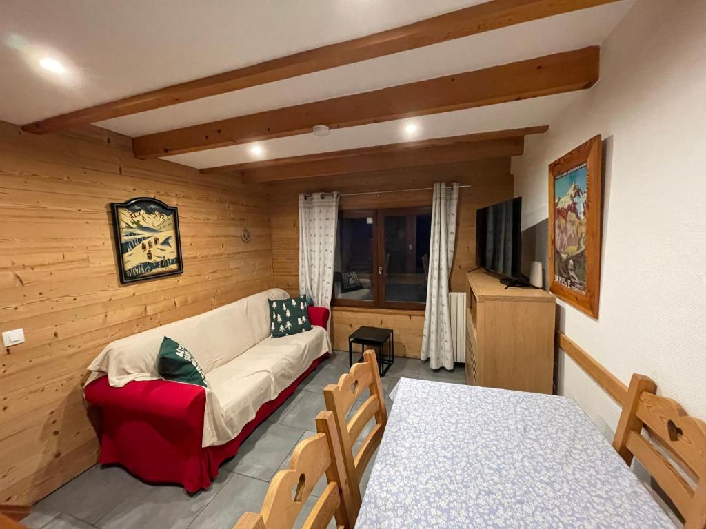 a living room with a couch and a table at L ALPIN bel appartement avec terrasse dans vieille ferme de montagne rénovée in Les Orres