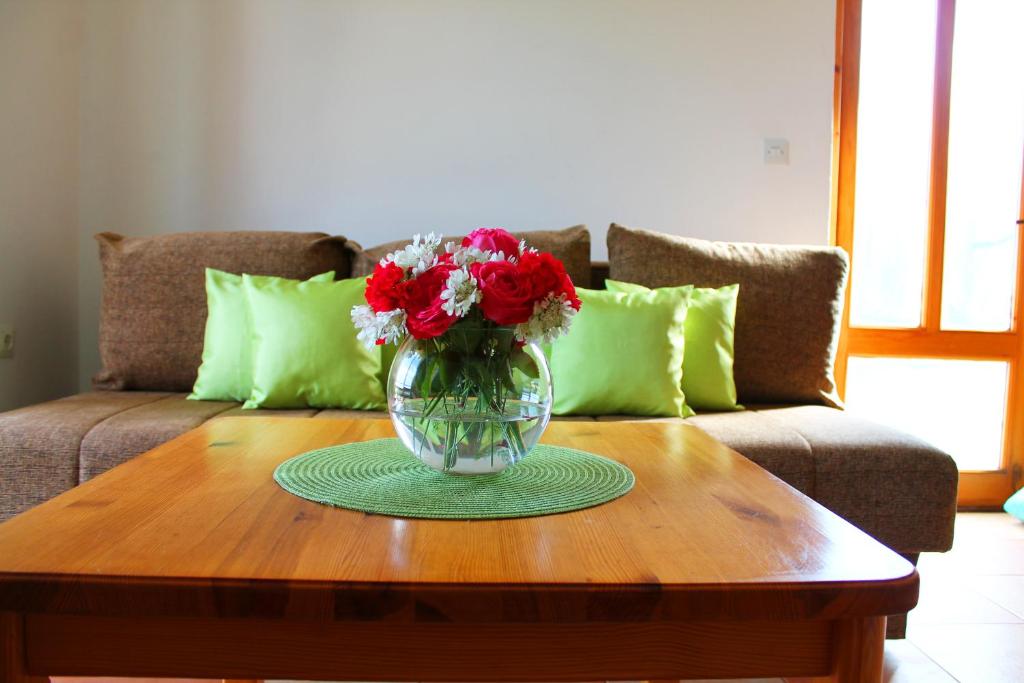 a vase of flowers sitting on a table in front of a couch at Apartments Villa Milna 1 in Budva