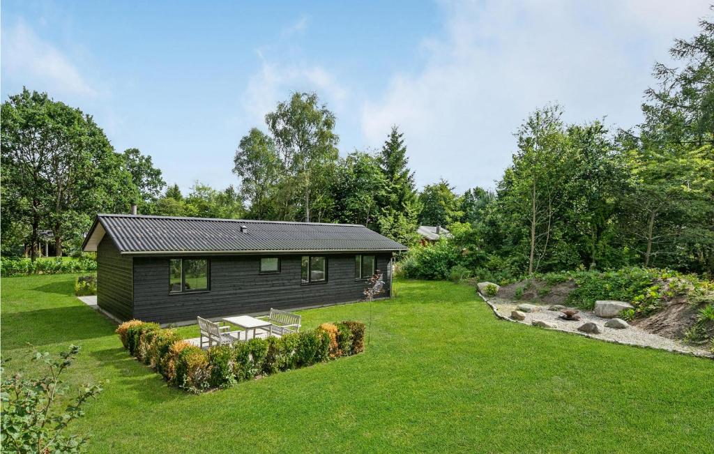 a small cabin in the middle of a yard at Nice Home In Frvang With Wifi, 5 Bedrooms And Outdoor Swimming Pool in Fårvang
