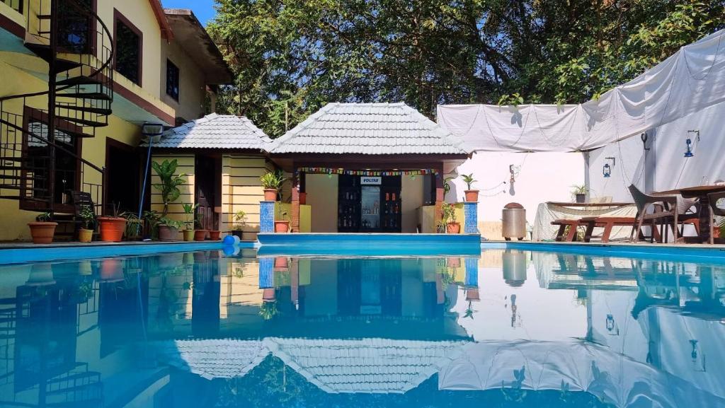 a house with a swimming pool in front of a house at Palolem Inn in Palolem
