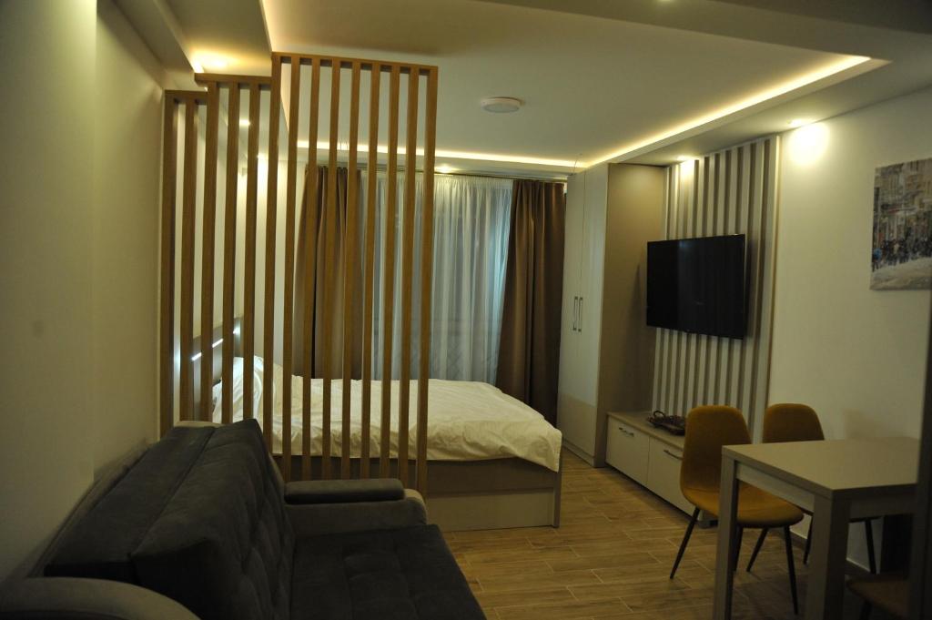 una stanza d'albergo con un letto, un tavolo e delle sedie di Apartman A20B a Kopaonik