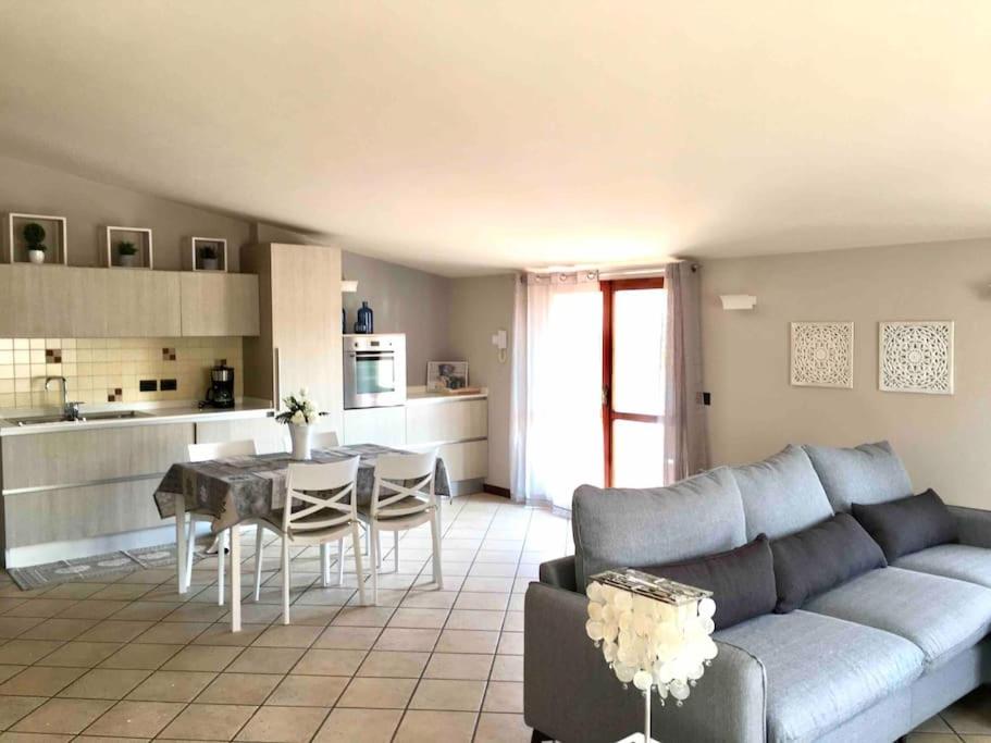 sala de estar con sofá, mesa y cocina en CASA CASTELLO en Padenghe sul Garda