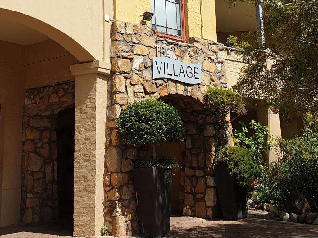 un edificio con un cartel que lee el pueblo en H4 Princess Beach duplex, en Ciudad del Cabo