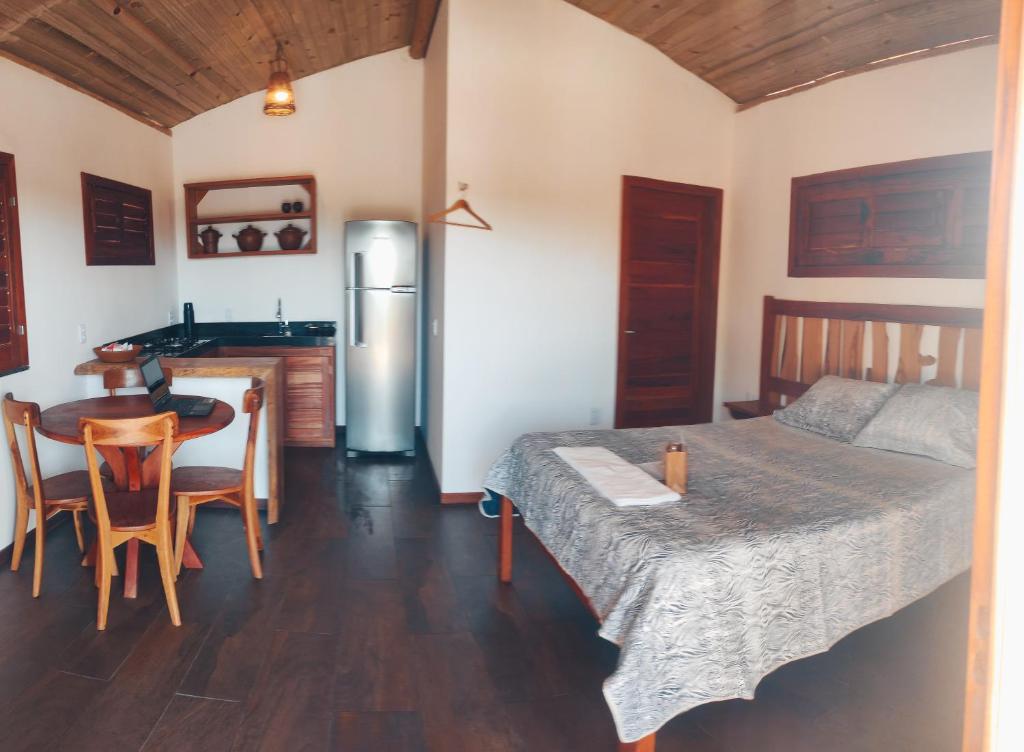 a room with a bed and a table and a kitchen at Bangalô pontal beach house in Fortim
