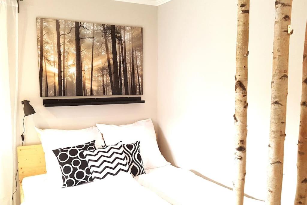 een slaapkamer met een bed met zwart-witte kussens bij Zimmer mit kleiner Dachterrasse / App. WALD byTILLY in Velden am Wörthersee