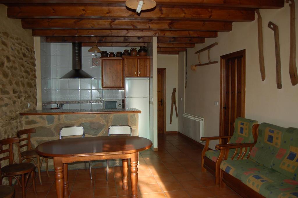 a kitchen and dining room with a table and chairs at Casita del jardin in El Bodón