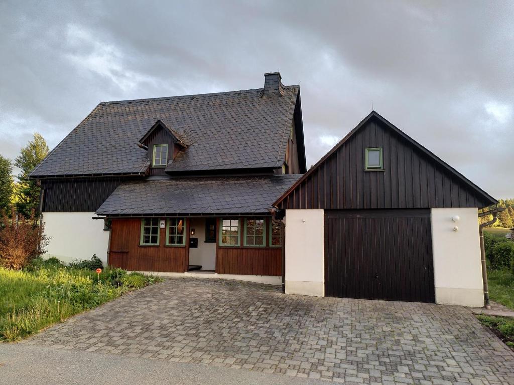 un granero grande en blanco y negro con entrada en Ferienhaus Schellerhäusl en Kurort Altenberg