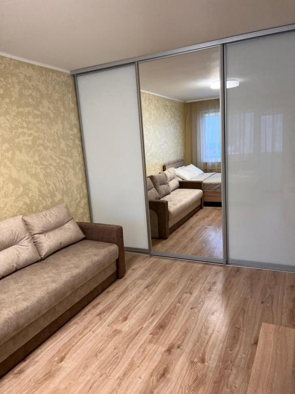 uma sala de estar com um sofá e um espelho em Prisma Apartment em Talin