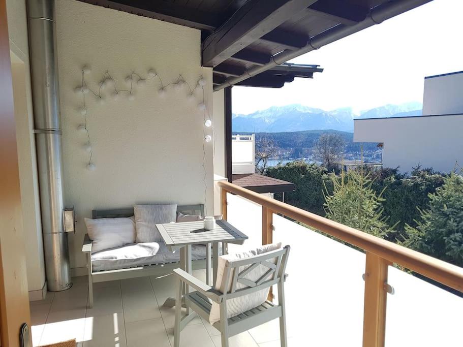 balcone con letto, tavolo e sedia di Wohnung mit Balkon in Velden - Appartment BERGE byTILLY a Velden am Wörthersee