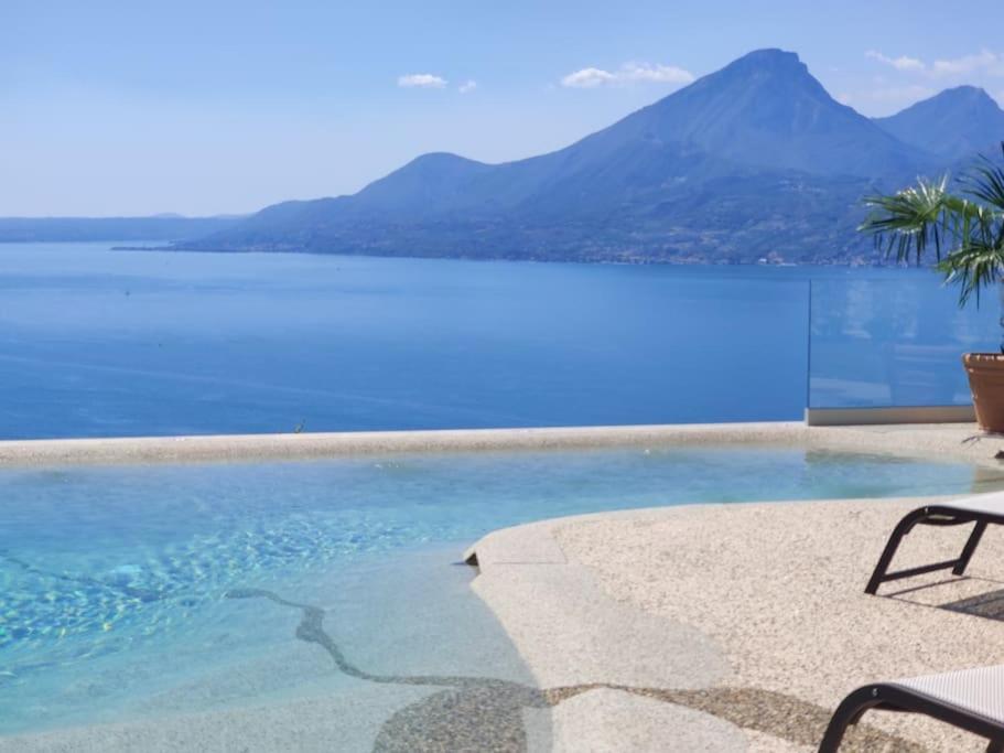 a swimming pool with a view of the water at Villa Divina22 - APT Prima con piscina e vista lago in Castelletto di Brenzone