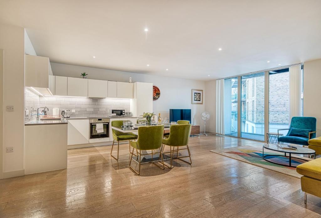 a kitchen and living room with a table and chairs at Austin David Apartments Royal Wharf in London